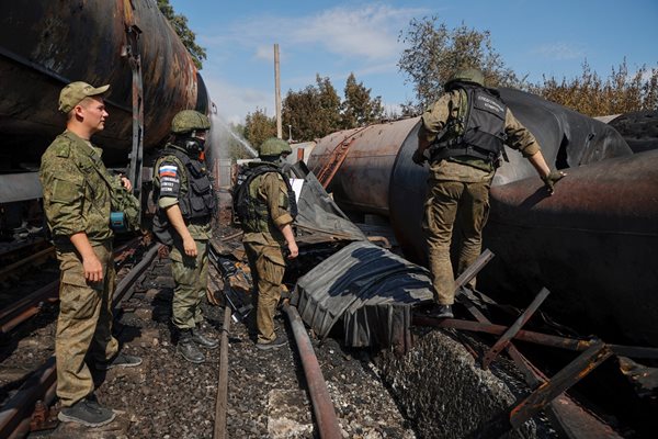 Руски военни следователи работят на мястото на пожар в петролно депо в Донецк.
СНИМКА: РОЙТЕРС