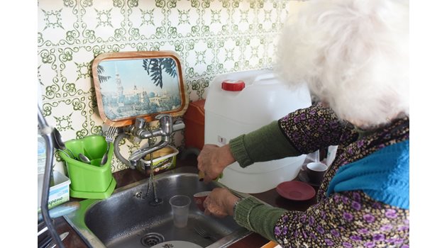 85-годишната Стефана Николова си помага в кухнята с 20-литров бидон с канелка. Водата се оттича в мивката и все едно, че има течаща вода вкъщи.