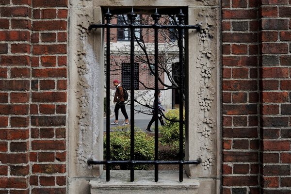 Студенти се разхождат в двора на Харвардския университет, който мина на виртуално обучение.