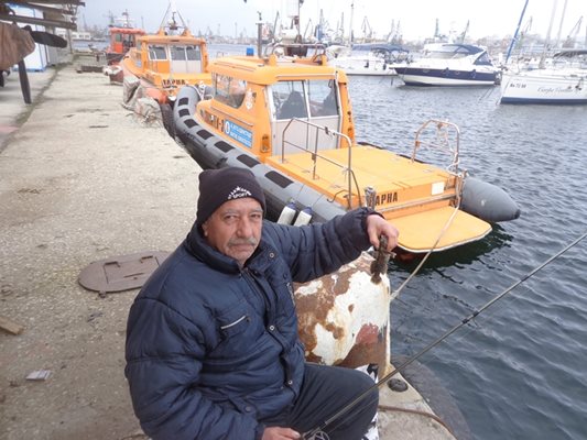 Охранителят  Янчо Тодоров лови попчета, които ураганният вятър от  югоизток  набута между  корабите във варненското  пристанище.