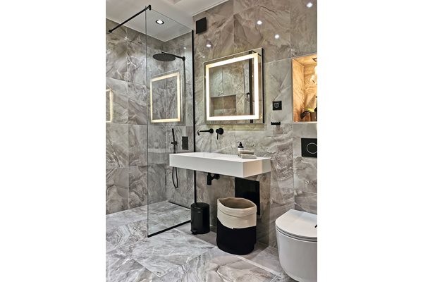 Голямата баня с красиво мраморно пано на стената и дизайнерски модел на WC на Филип старк