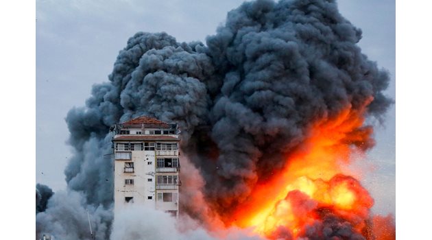 Дим и пламъци се издигат, след като Израел е ударил сграда в Газа.