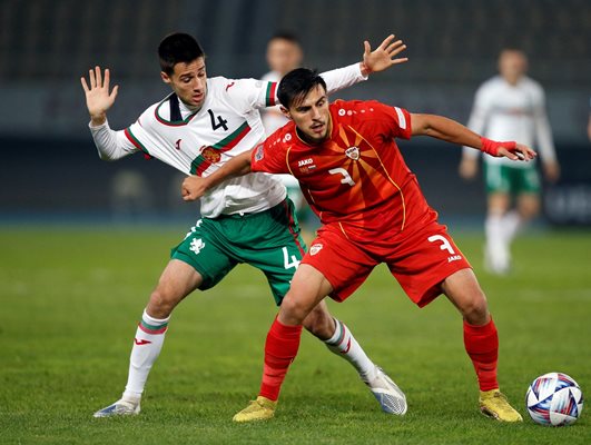 Северномакедонецът Елиф Елмас опитва да свали българската фланелка на Илия Груев при победата на България с 1:0 в Скопие.