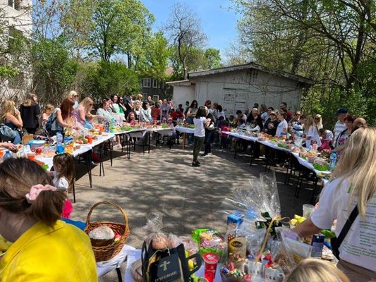 На масата, подредена в кръг, жени и деца празнуваха Великден на открито и се молеха за мир. 
