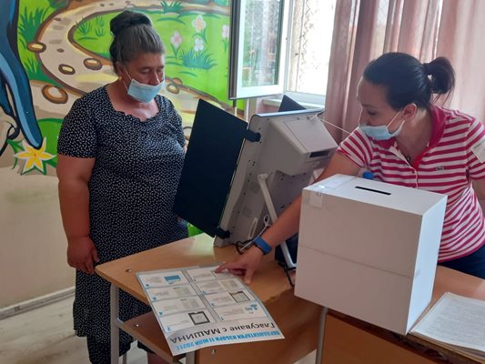 В "Столипиново" член на комисия обяснява на избирателка как да гласува на машината