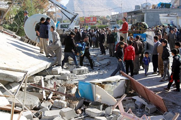 Жители оглеждат останките от срутена от труса сграда в иракския град Дарбандикхан.