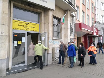 Възрастни хора на опашка за пенсии пред пощенски клон.