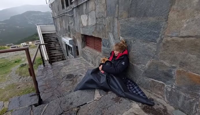 Кадър от видеото, което Мира Добрева споделя в профила си във фейсбук. На него се вижда как журналистката седи отвън пред хижата, прегърнала малкото си кученце.