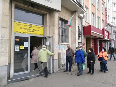 Възрастни хора на опашка за пенсии пред пощенски клон.