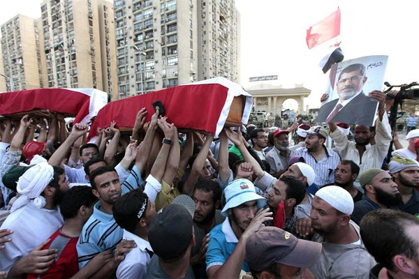 Привърженици на Мохамед Мурси носят фалшиви ковчези в памет на 4-ма свои съратници, убити в сблъсъци с полицията.