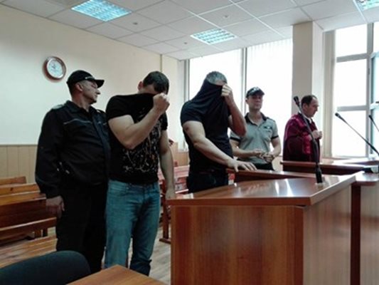 Полицаите Стефан Модев и Петър Атанасов крият лицата си в съда.