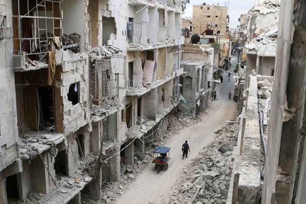 Жители се разхождат сред отломки от сгради в стария град на Алепо.