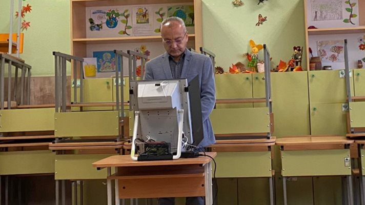 Премиерът Гълъб Донев гласува на изборите през октомври 2022 г. Двете капачета отстрани на машината също са параван и не позволяват да се види за кого се гласува.