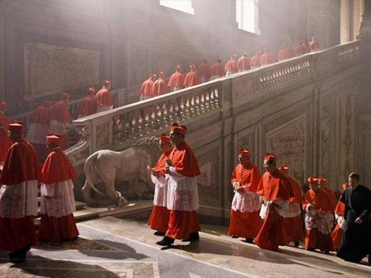 Фигурата на шамбелана (Юън Макгрегър) се откроява в живописната процесия на кардиналите на Ватикана. 
