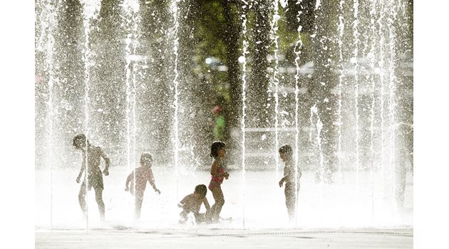 Деца играят във фонтан по време на необичайна жега в швейцарския град Цюрих.