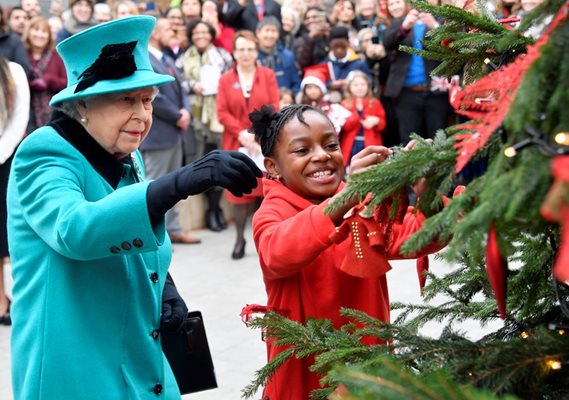 Британската кралица Елизабет Втора украсява коледно дърво на благотворително събитие в Лондон Снимки: Ройтерс;
