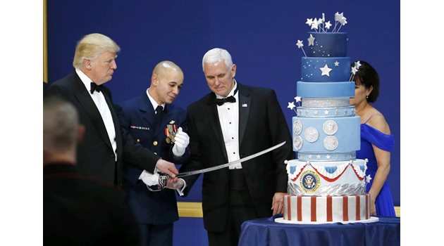 Новият държавен глава и вицепрезидентът Майк Пенс разрязват със сабя торта на бала на военните.