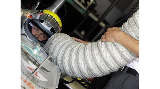ЖЕГА: Механик от отбора е насочил тръбата на вентилатора към Нико Розберг, за да охлажда тялото на пилота, което е изложено на високите температури по време на всяко състезание.