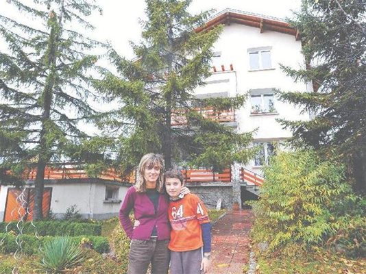 Диана Върбенова и синът й (вляво) пред къщата си в Горна баня, възстановена след удара на НАТО преди 10 години.