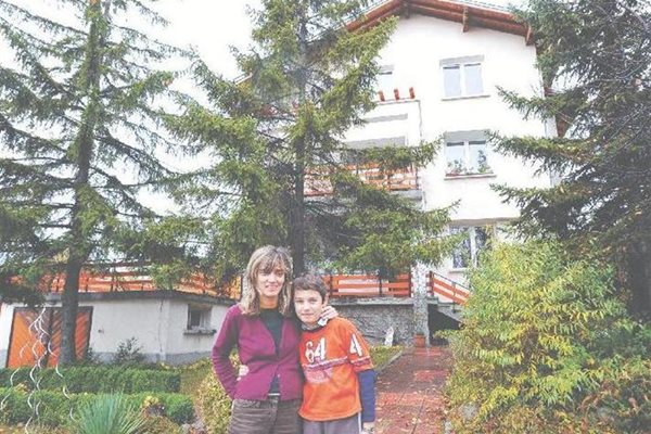 Диана Върбенова и синът й (вляво) пред къщата си в Горна баня, възстановена след удара на НАТО преди 10 години.