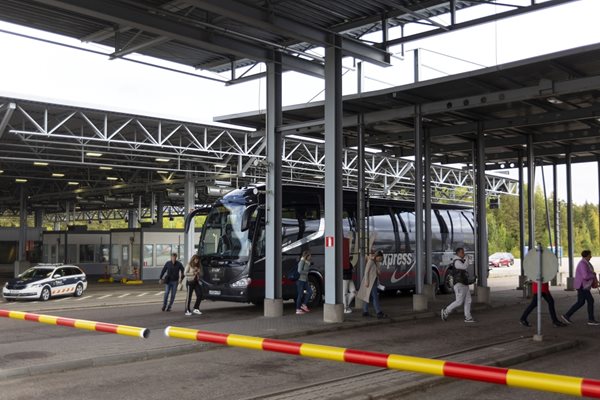 Руснаци слизат от автобус за паспортна проверка на границата с Финландия.