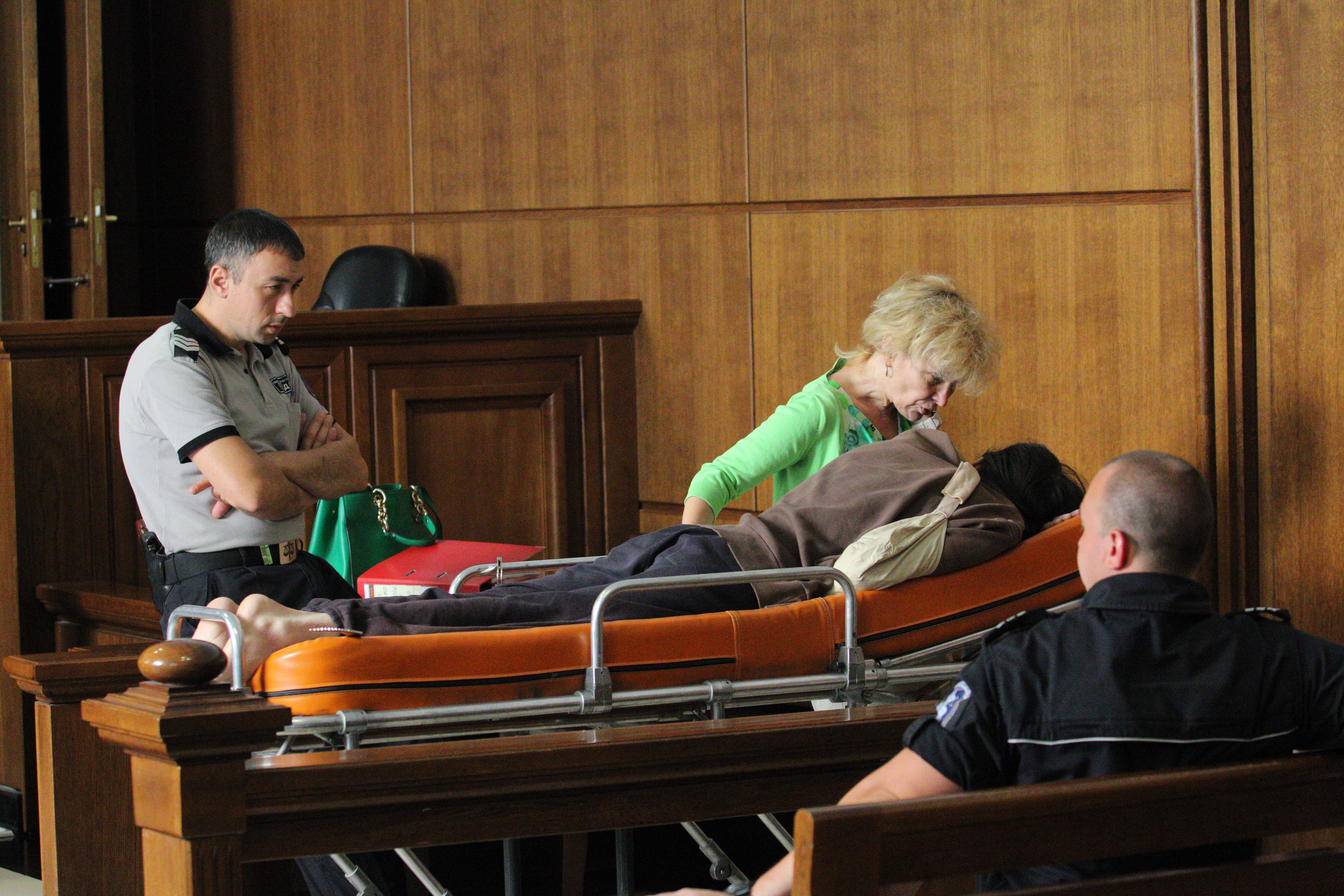Съдебни охранители за пореден път конвоираха руснака на носилка в Софийския градски съд. До него е адвокатката му Капка Гергинова.