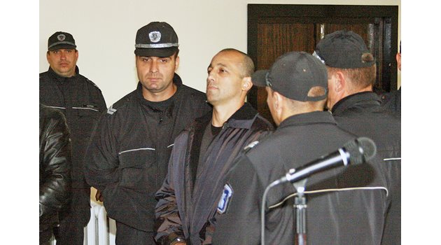 Полицаи водят Фрико към съдебната зала.