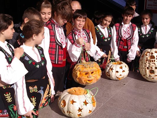 Българчета в народни носии показват тиквените фенери, които сами са изработили за Хелоуин.