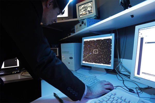 Испански астроном следи движението на астероида в реално време на екран в обсерваторията в Сабадел.