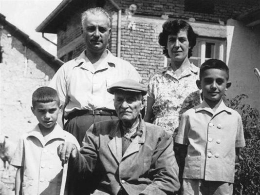 Димитър Томов като дете (вляво) с дядо си Тома през 1965 г. в Павликени. Отзад се вижда кирпичената им къща, изградена на мястото на първата семейна землянка.
