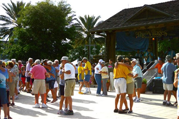 Пенсионери танцуват на площада в колонията.

