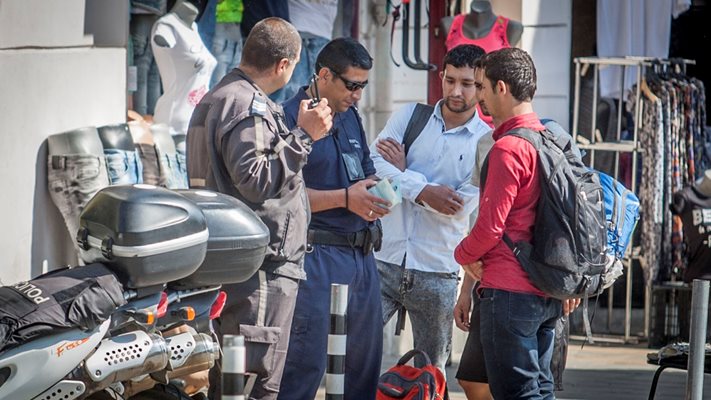 Полицаи проверяват документите на мигранти на столичния “Женски пазар”.