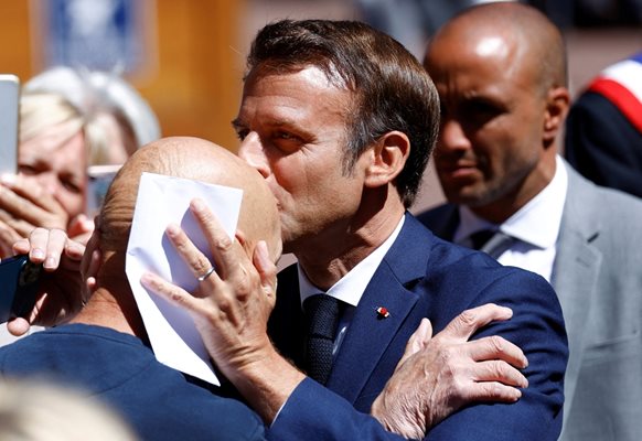 Еманюел Макрон целува свой привърженик, след като гласува на парламентарните избори.