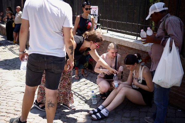 Жена получава помощ, след като ѝ е прилошало от жегата в Италия. СНИМКА: РОЙТЕРС