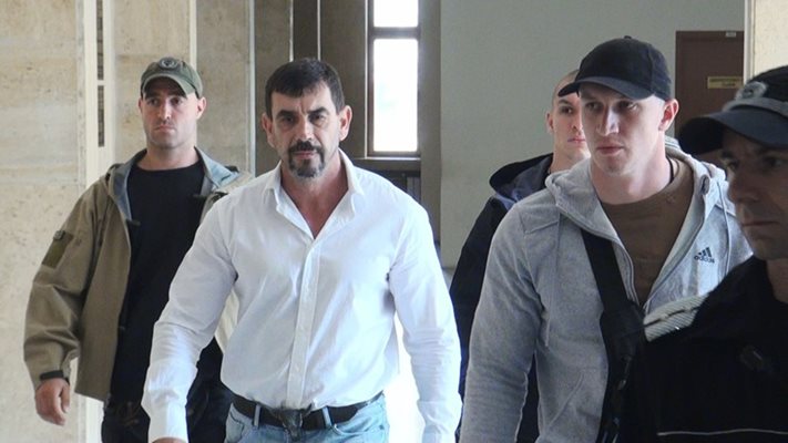 Тодор Неделчев с един охранител пред него и двама зад гърба му. Той не пожела да коментира връщането на делото в прокуратурата. Снимка: Елена Фотева