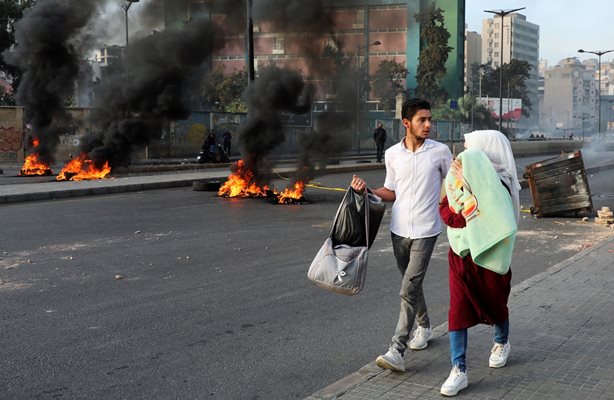 Хора вървят с бебе по блокиран със запалени гуми път заради протест срещу лошите условия на живот в Бейрут, Ливан, през 2021 г.
СНИМКА: РОЙТЕРС