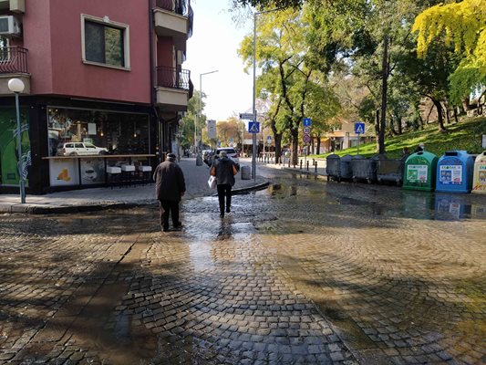 Пешеходци заобикалят дълбоките локви на кръстовището край Понеделник пазара. 