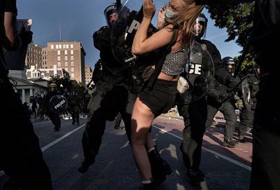 Полицаи арестуват жена, протестираща в парка до Белия дом. СНИМКА: РОЙТЕРС
