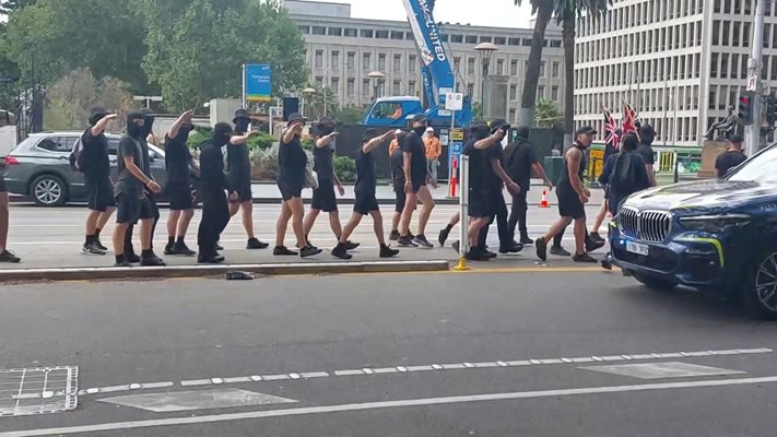 Мъже, облечени в черно, с вдигнати ръце в нацистки поздрав по време на протест в Мелбърн, Австралия. СНИМКА: РОЙТЕРС