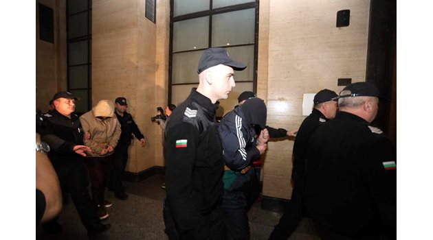 Петър Александров (с черната качулка) и Александър Кинов (задържаният зад него) остават в ареста, реши съдът.