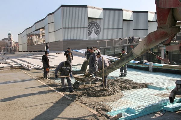 Работници изливат бетон и се радват, че времето е с тях.
