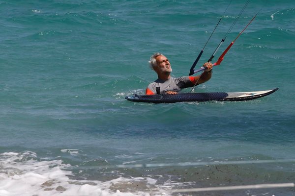 Стефан се бори да вдигне платното на сърфа от морската вода