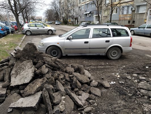 Старата настилка е струпана около паркираните автомобили.