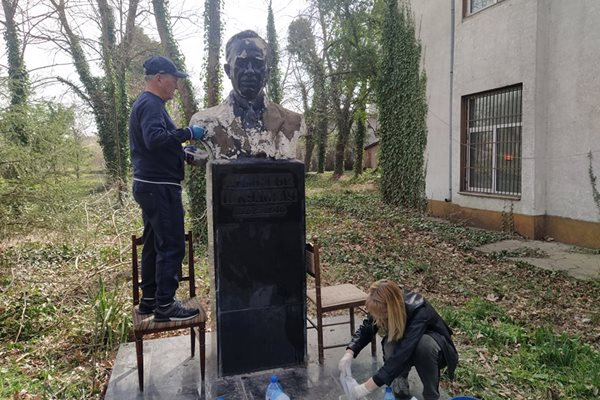Покачен на стол, Димитър Георгиев запълва с шпатула вдлъбнатините по паметника на Кудоглу.
