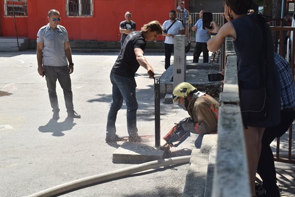 Огнеборец сряза бариерата, за да може да влезе водоноска в двора на школото.