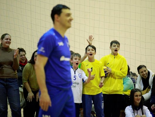 Алекс и Мони (с жълтите екипи) аплодират баща си, докато играе с групи от школата му.