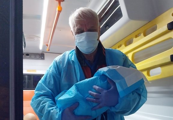 Фелдшерът Радко Радев с изроденото бебе на ръце.