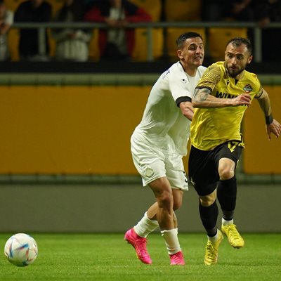 Футболистът на "жълто-черните" Николай Минков се бори за топката с противников футболист.