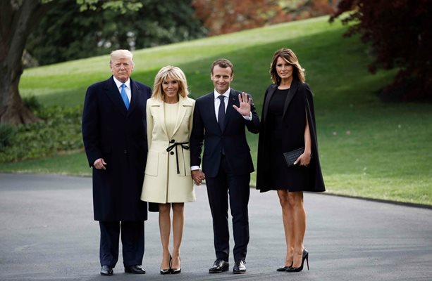 За частната вечеря на президентските семейства Брижит Макрон избра късо палто в жълто-кремаво, а Мелания Тръмп вечерно-смокинг-пелерина и малка черна рокля.
