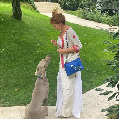Мария Петрова с кучето си от порода ваймаранер в двора на имението